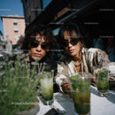 Fashionable Women Enjoying Drinks on a Sunny Outdoor Patio