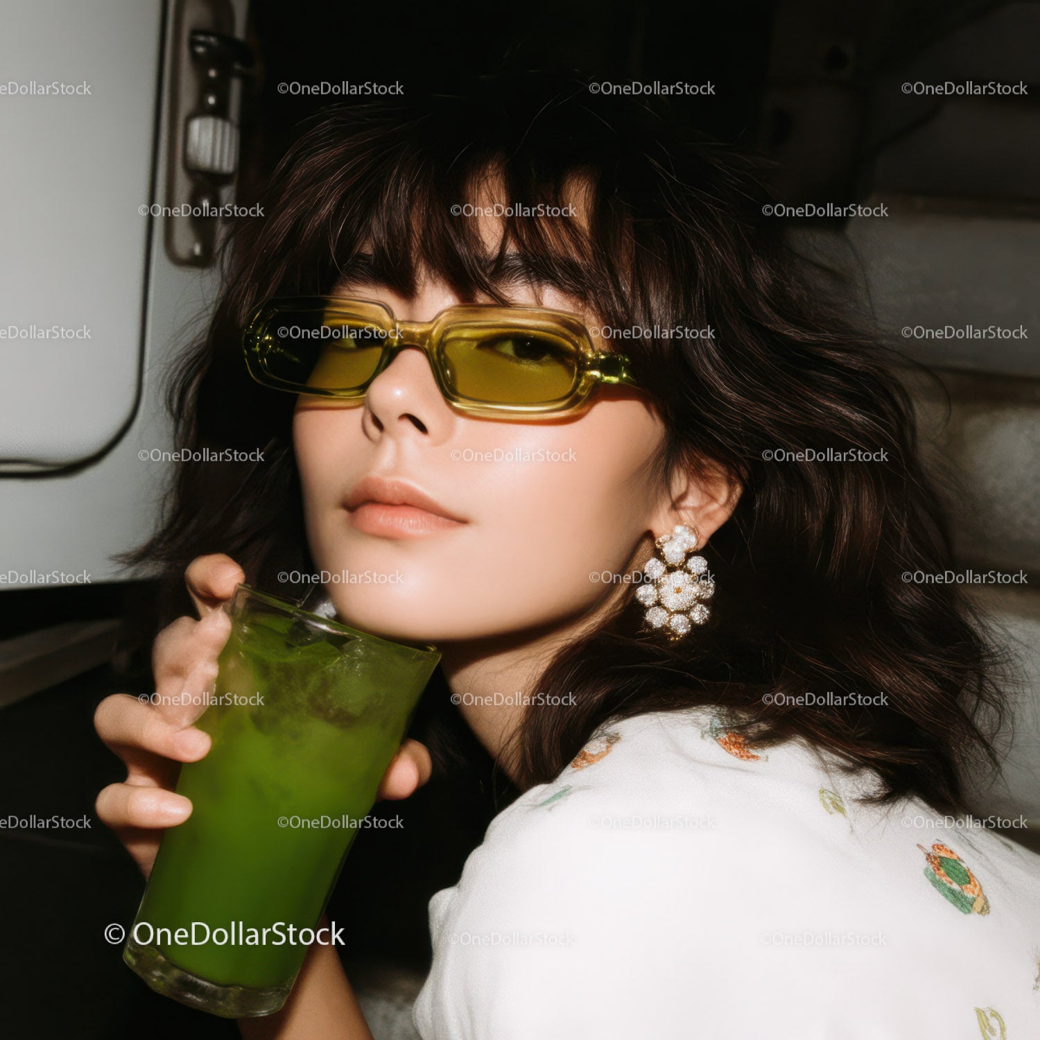 Fashionable Woman with Yellow Sunglasses Holding Green Cocktail in Stylish Setting