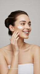 Smiling Woman Applying Face Cream for Healthy Skin