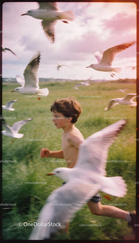Young boy running joyfully among flying seagulls