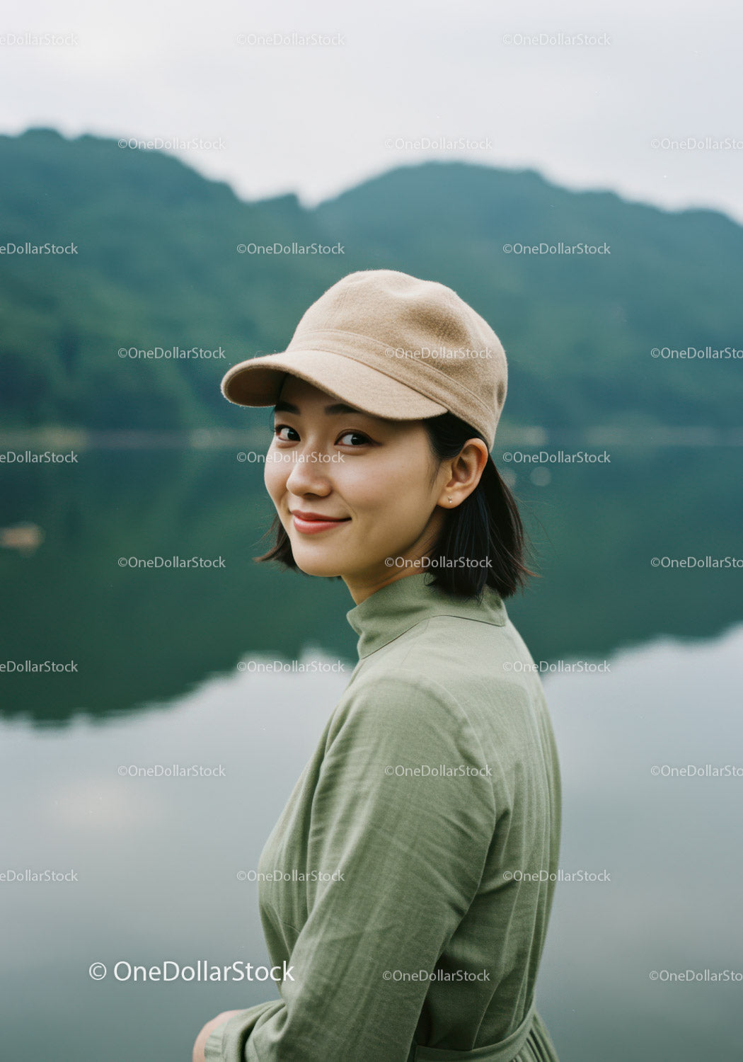 Young Woman in Green Dress Wearing Beige Cap Near Lake Landscape