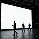 Silhouettes of People Walking Past Large Bright Screen