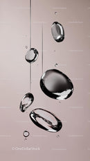 Close-up of Water Droplets Falling Against Soft Pink Background