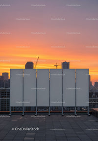 Modern City Skyline with Sunset Sky and Construction Cranes