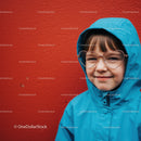 Smiling child in blue raincoat with heart glasses