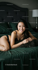 Smiling woman relaxing on bed in minimalistic room