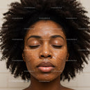 Close-up of Black Woman with Curly Hair Applying Face Mask for Skincare