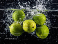 Fresh Green Limes Splashing Into Water in Motion