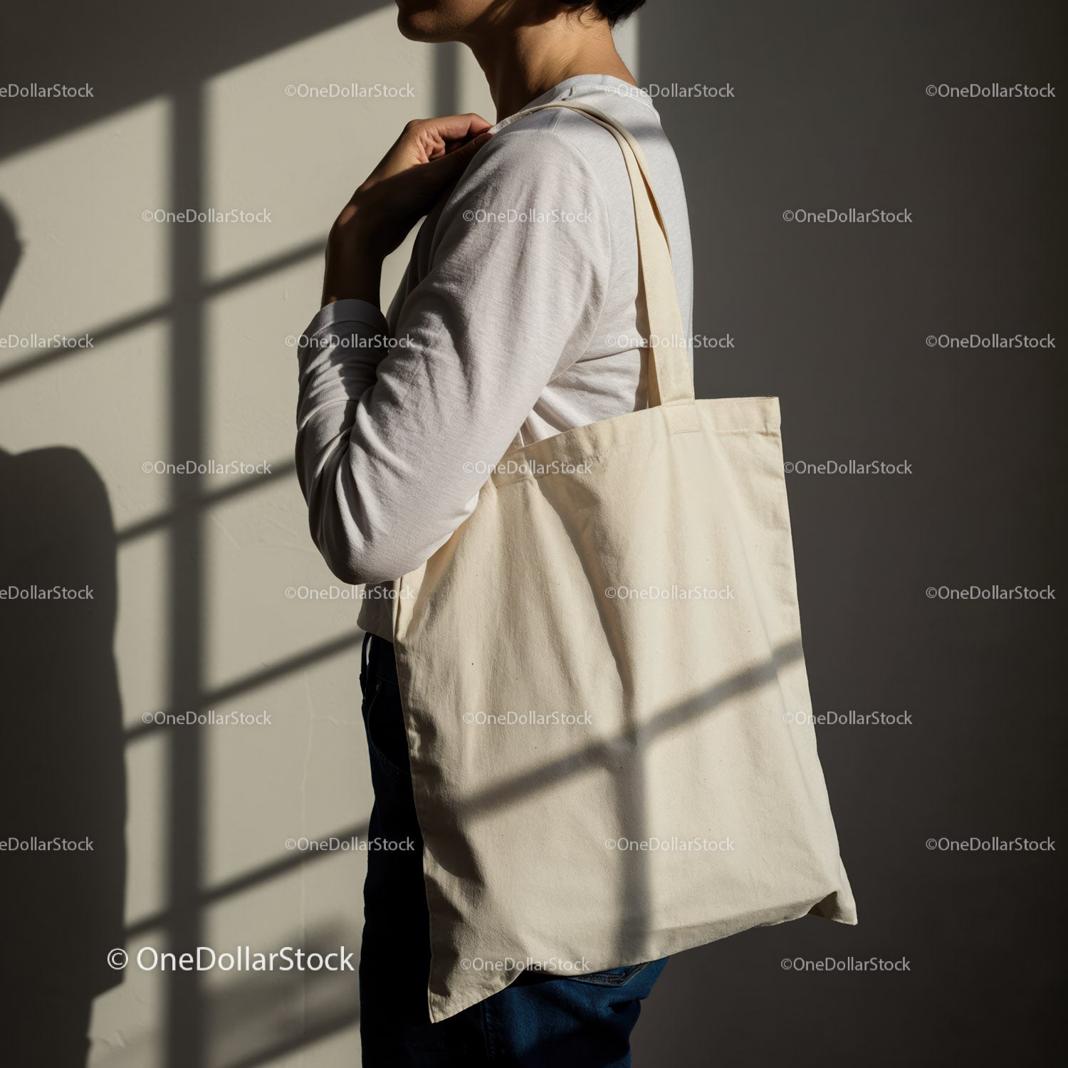 Person carrying blank canvas tote bag in soft light