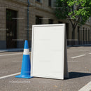 Blank white sandwich board with blue traffic cone outdoors