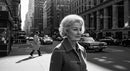 Elegant Elderly Woman Walking in Business District on City Street