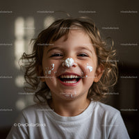 Happy child laughing with whipped cream on face