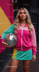 Young Woman in Colorful Tracksuit Holding Disco Ball in Urban Setting