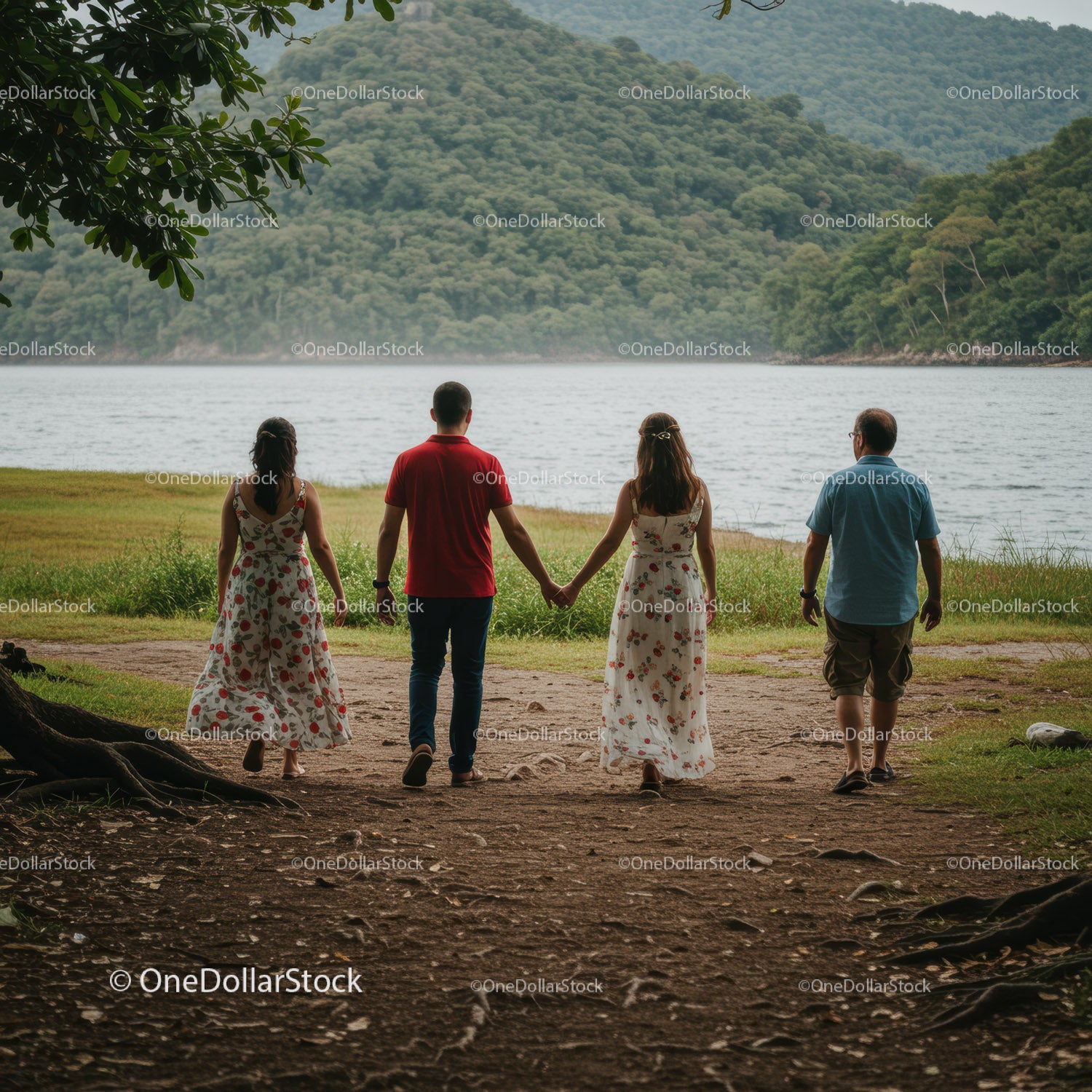 Family Walking Along Lake Shore with Green Hills and Trees