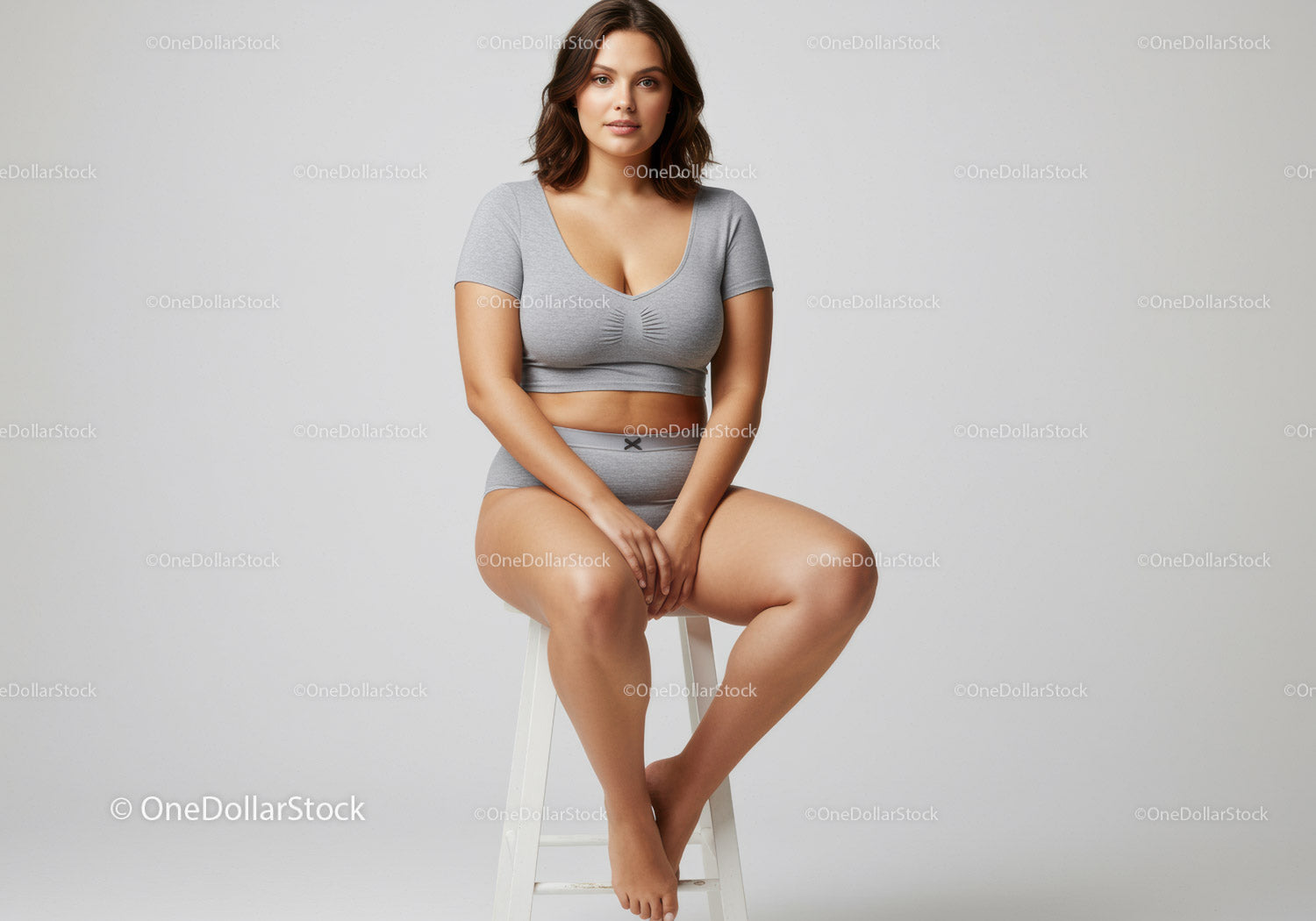 Confident Young Woman Sitting in Casual Gray Outfit on Stool