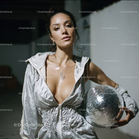 Stylish Woman in Metallic Outfit Holding Disco Ball for Modern Fashion