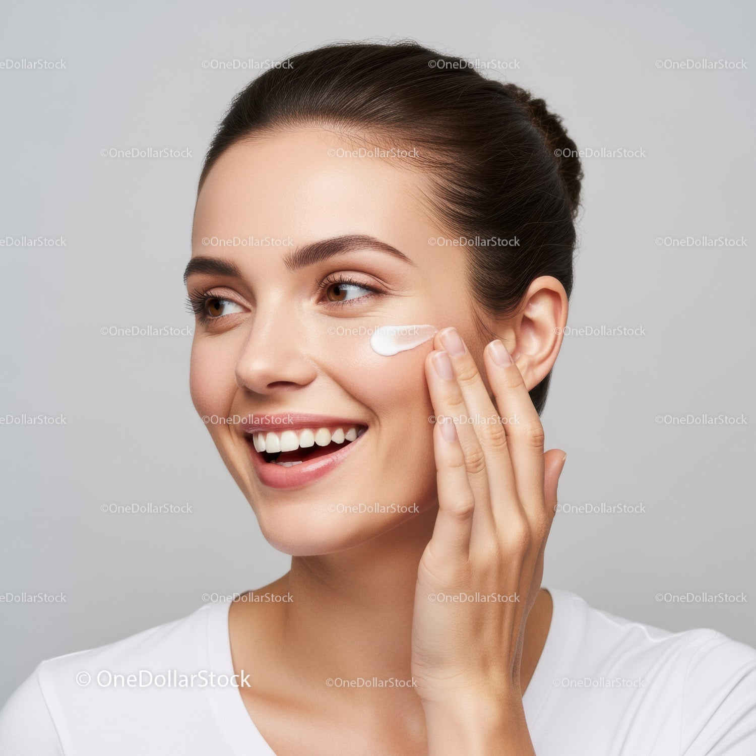 Young Woman Applying Facial Moisturizer with a Bright Smile