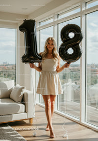 Young woman celebrating 18th birthday with balloons indoors