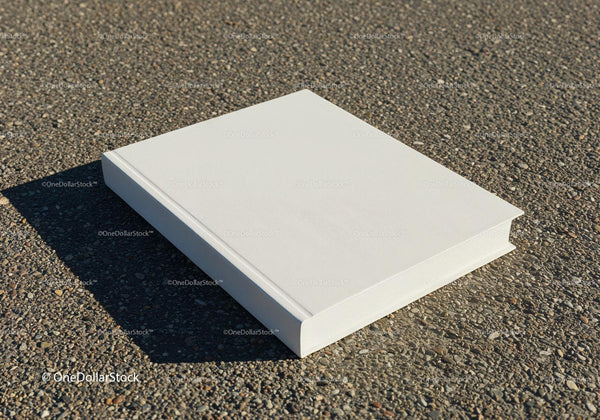 Blank white hardcover book on pebble ground outdoors JPG Mockup Image