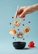 Fresh sushi rolls lifted with chopsticks over soy sauce bowl