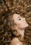 Young woman with flowing curly blonde hair and closed eyes