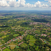 Aerial View of Rural Village with Green Farmlands and Scattered Houses