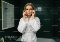 Young Woman Applying Under Eye Patches in Bathroom Spa Setting