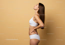 Young Slender Woman in White Sportswear Smiling in Studio Portrait