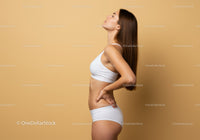 Young Slender Woman in White Sportswear Smiling in Studio Portrait