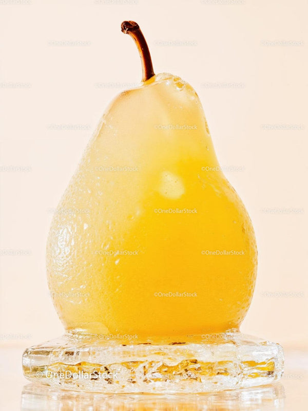 Fresh yellow pear encased in melting ice cube