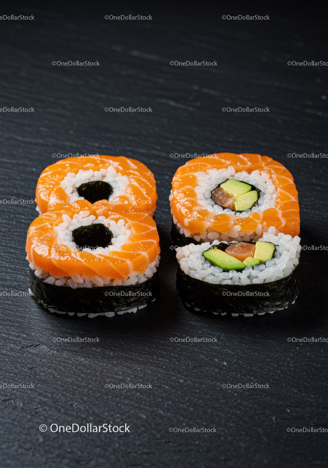 Fresh salmon sushi rolls arranged on dark surface