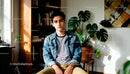 Thoughtful young man sitting in cozy home library