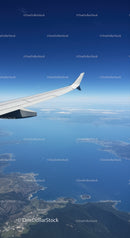 Aerial View of Airplane Wing Over Coast and Mountains