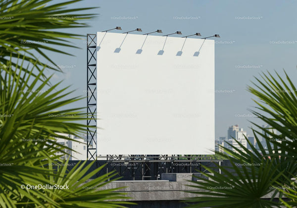 Blank billboard on rooftop framed by palm leaves JPG Mockup Image