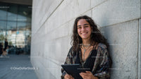 Young Woman Smiling with Tablet in Urban Outdoor Setting