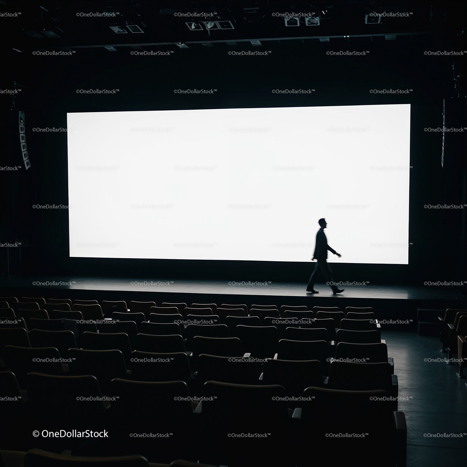 Silhouette of man walking past blank cinema screen