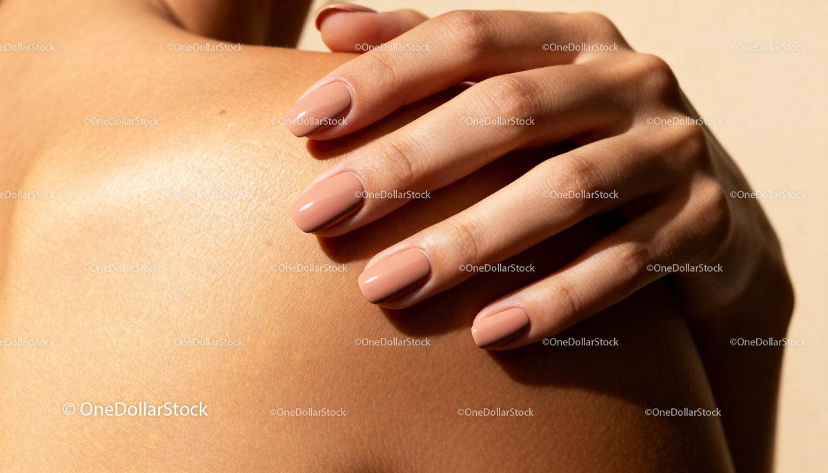 Close-up of manicured hand resting on smooth shoulder