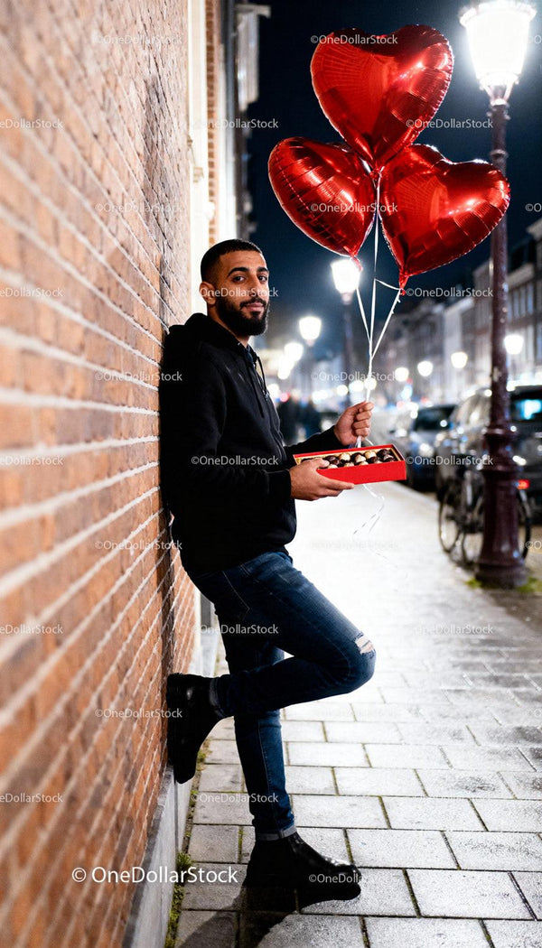 Man Holding Heart Balloons and Chocolates on City Street