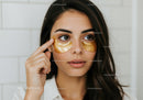 Young Woman Applying Gold Eye Patches for Skincare Beauty