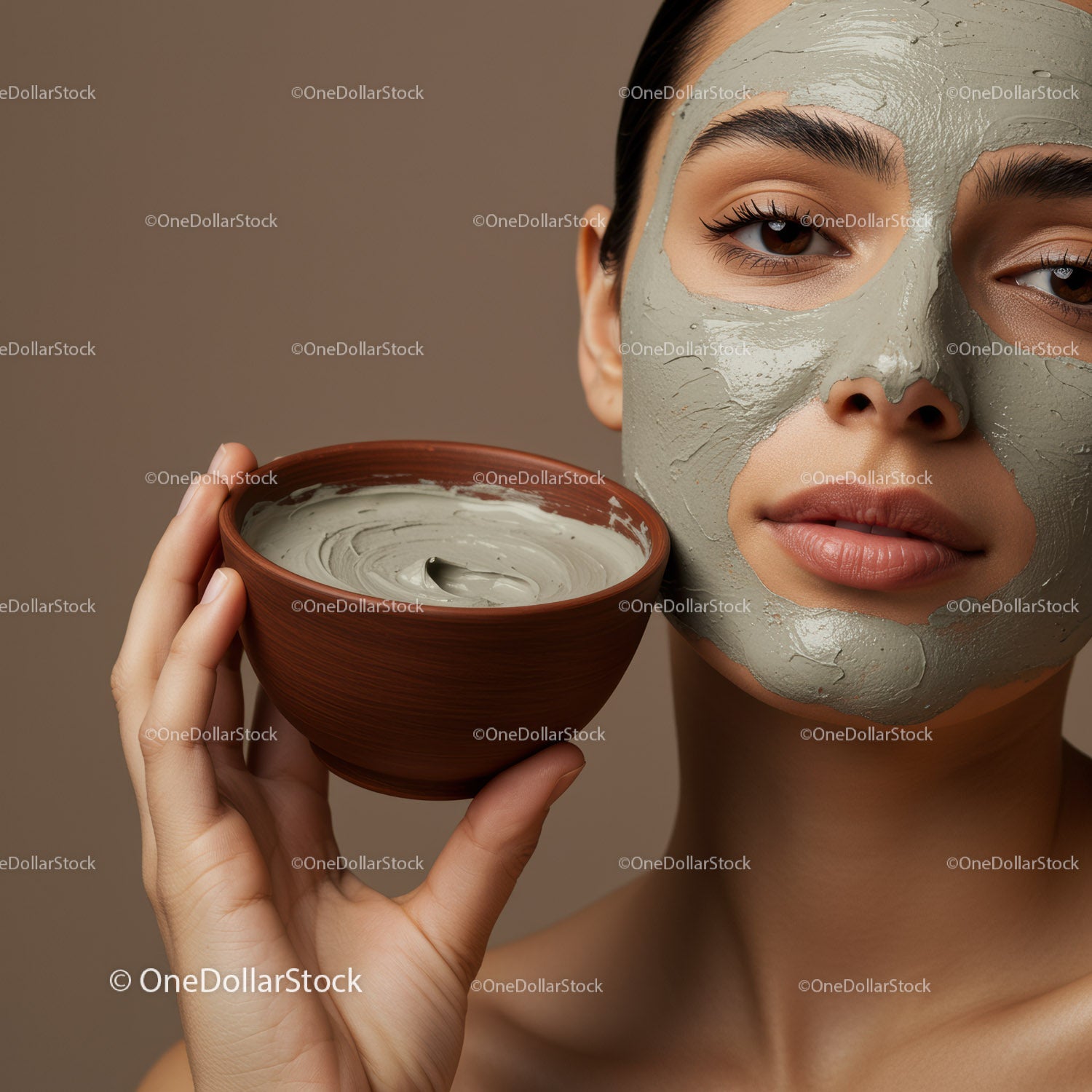 Young Woman with Gray Clay Facial Mask Holding Clay Bowl for Skincare