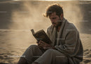 Man Reading a Book by the Seaside at Sunset