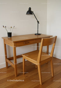 Wooden Desk and Chair with Black Lamp and Lavender Flowers in Cozy Home Office
