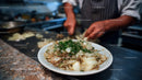 Hands of a Chef Preparing Fresh Chopped Onions in Kitchen