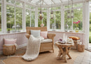 Cozy wicker chair in bright sunroom with natural decor