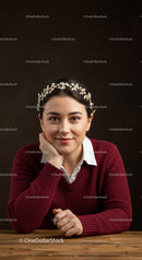 Young woman with floral headband smiling at camera