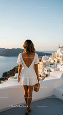 Woman in White Dress Enjoying Santorini Sunset View