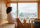 Relaxing Woman Sitting in Sauna with City View in Modern Wellness Center