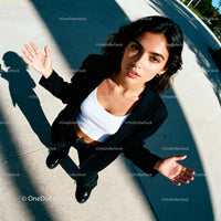 Confident young woman standing outdoors with open hands