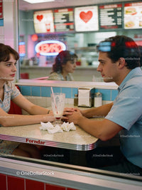 Young couple sharing tender moment in retro diner
