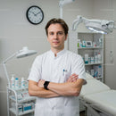 Male Doctor Standing Confidently in Medical Clinic with Modern Equipment